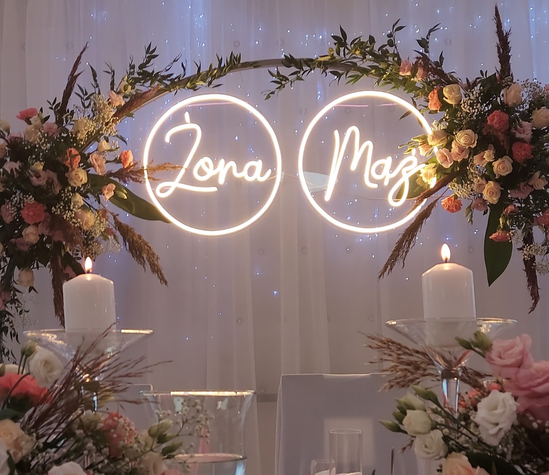 Dekoracja weselna z neonami Żona i Mąż w kwiatowej obręczy