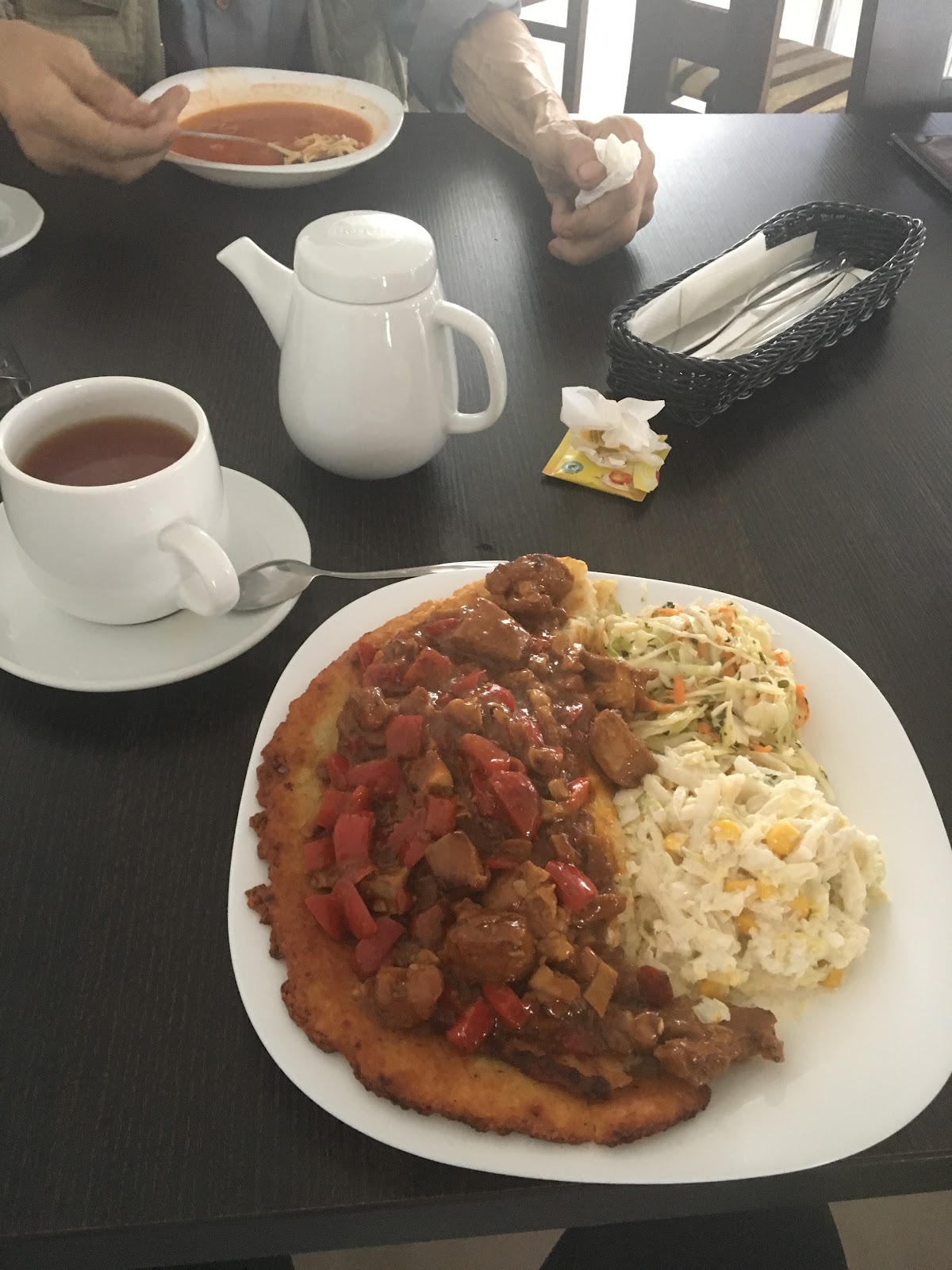 Placek po węgiersku podany z surówkami, herbata i zupa w tle
