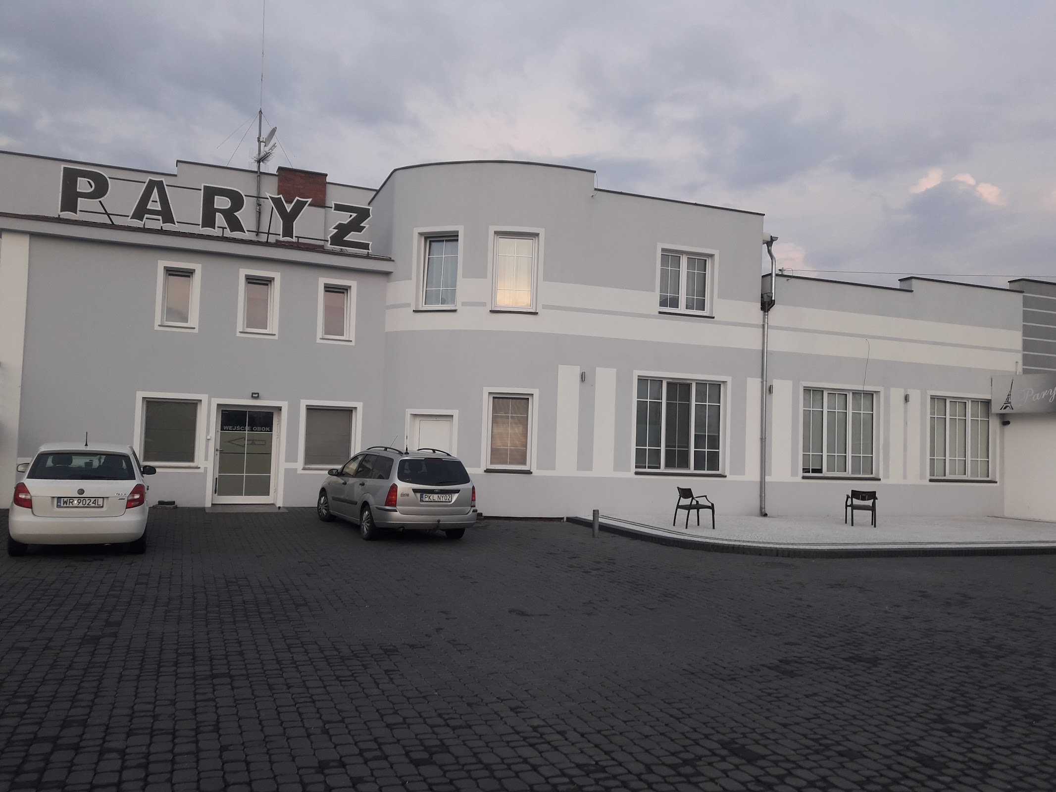 Zajazd Paryż od strony parkingu, szyld PARYŻ i wejście do sali