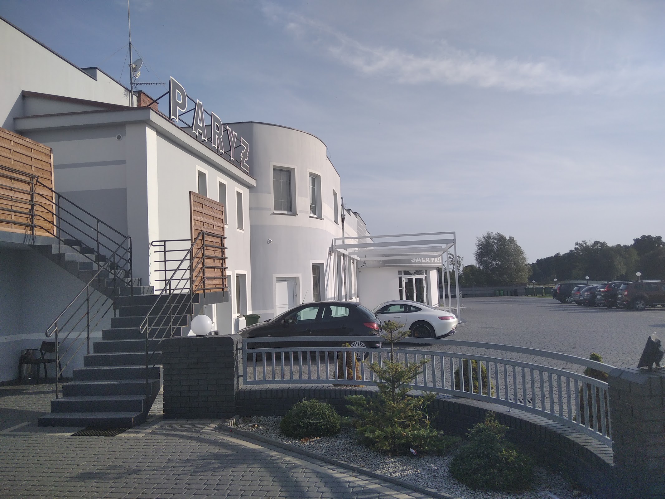 Budynek Zajazdu Paryż w Grzegorzewie z szyldem PARYŻ i parkingiem przed wejściem